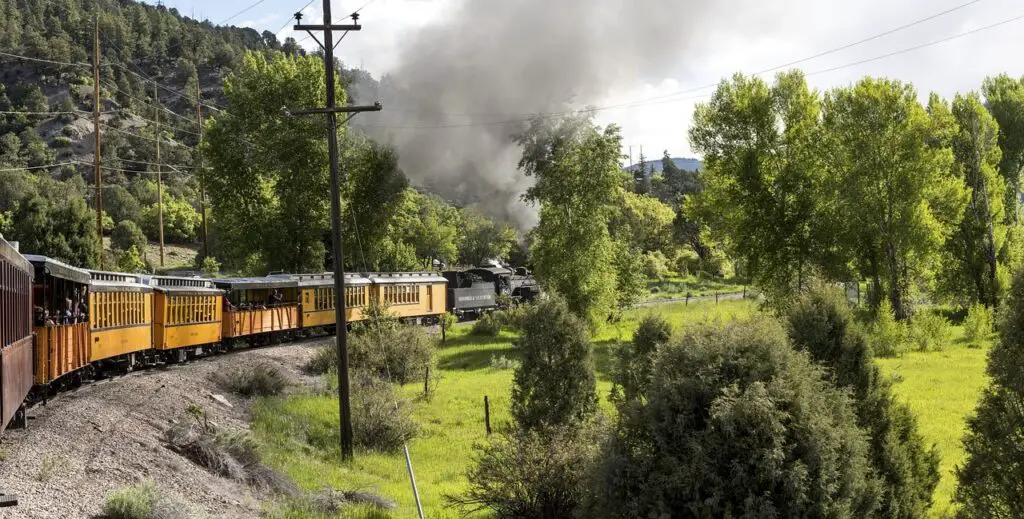 A scenic train winding through the natural beauty and mountains of Durango, Colorado, showcasing free things to do in Durango