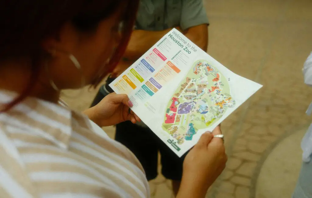 Plan Your Visit: Tips and Itinerary Outline for Springfield, IL Young woman looking at a zoo map while planning her visit, a key stop in a Springfield, IL itinerary.