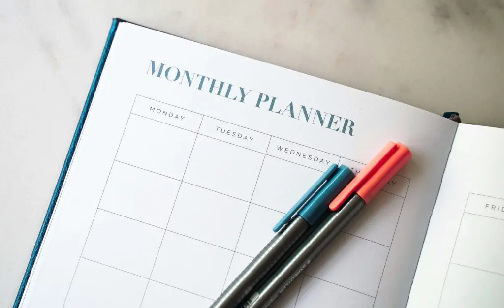 Two glasses of wine next to a planner or journal on a cozy table, setting the mood for a date night in Naperville.