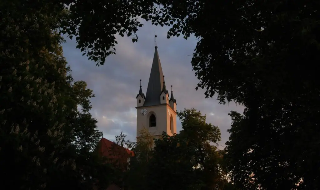 Exploring Schaumburg’s Rich Local Culture and History: Fun Things to Do for Adults Scenic view through the trees of the most iconic castle-like building in Schaumburg, surrounded by greenery.
