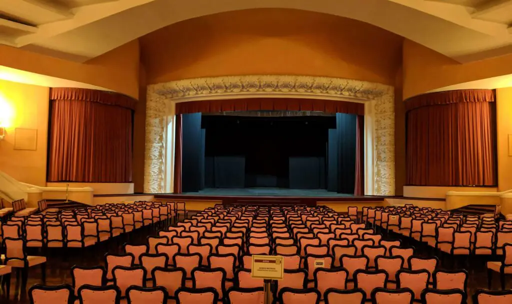 Live Theater and Music Venues: Fun Things to Do in Schaumburg for Adults Interior of a theater in Schaumburg with elegant seating and a lit stage, ready for a live performance.