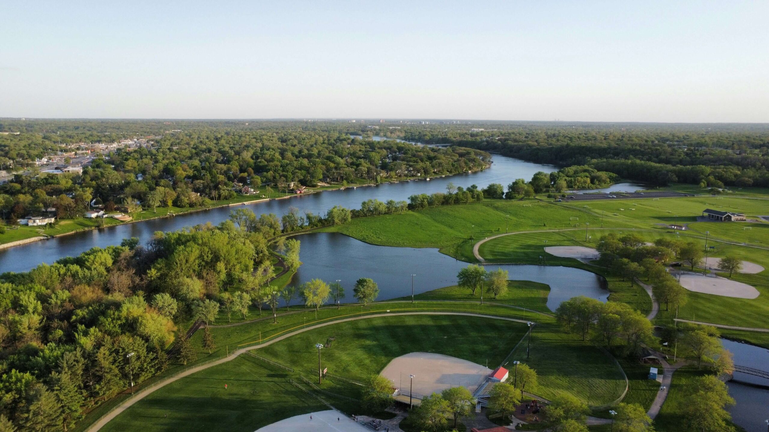 Peaceful nature scene in Rockford, Illinois, with trees, a walking trail, and city elements blending in the background.