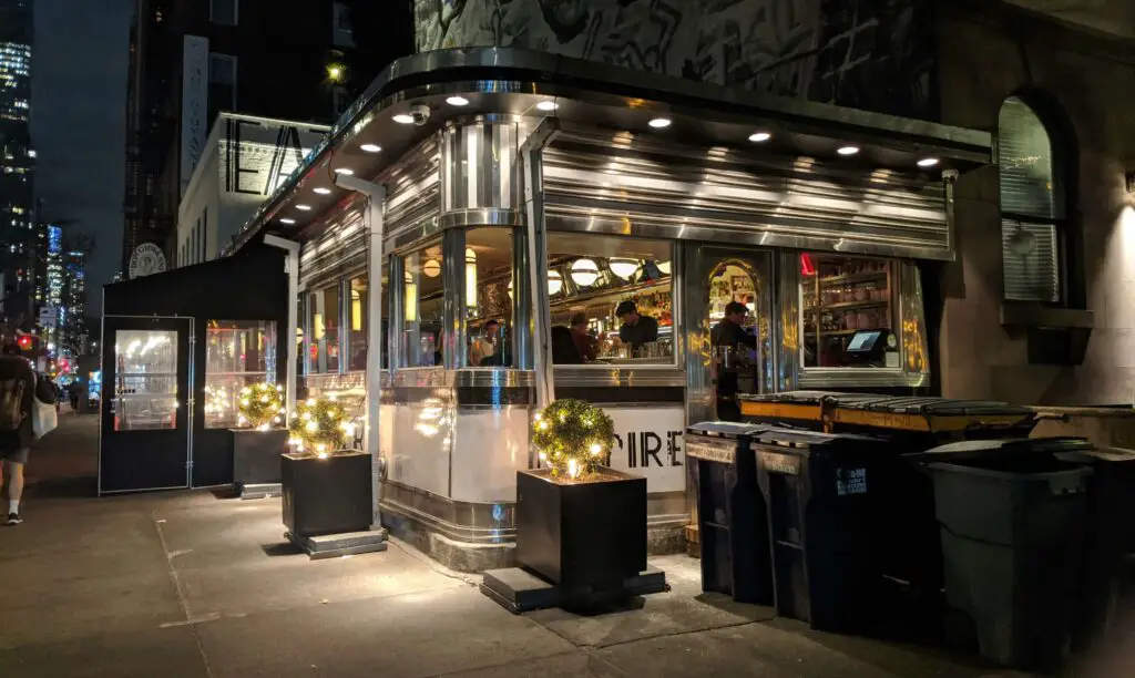 SoHo NYC Restaurants with Outdoor Seating: Culinary Delights Under the Sky Charming restaurant exterior in SoHo, NYC with outdoor seating and cozy evening ambiance.