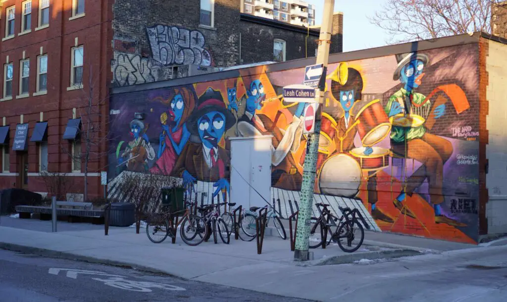 Colorful street art covering building walls along a vibrant street in East Village, NYC.