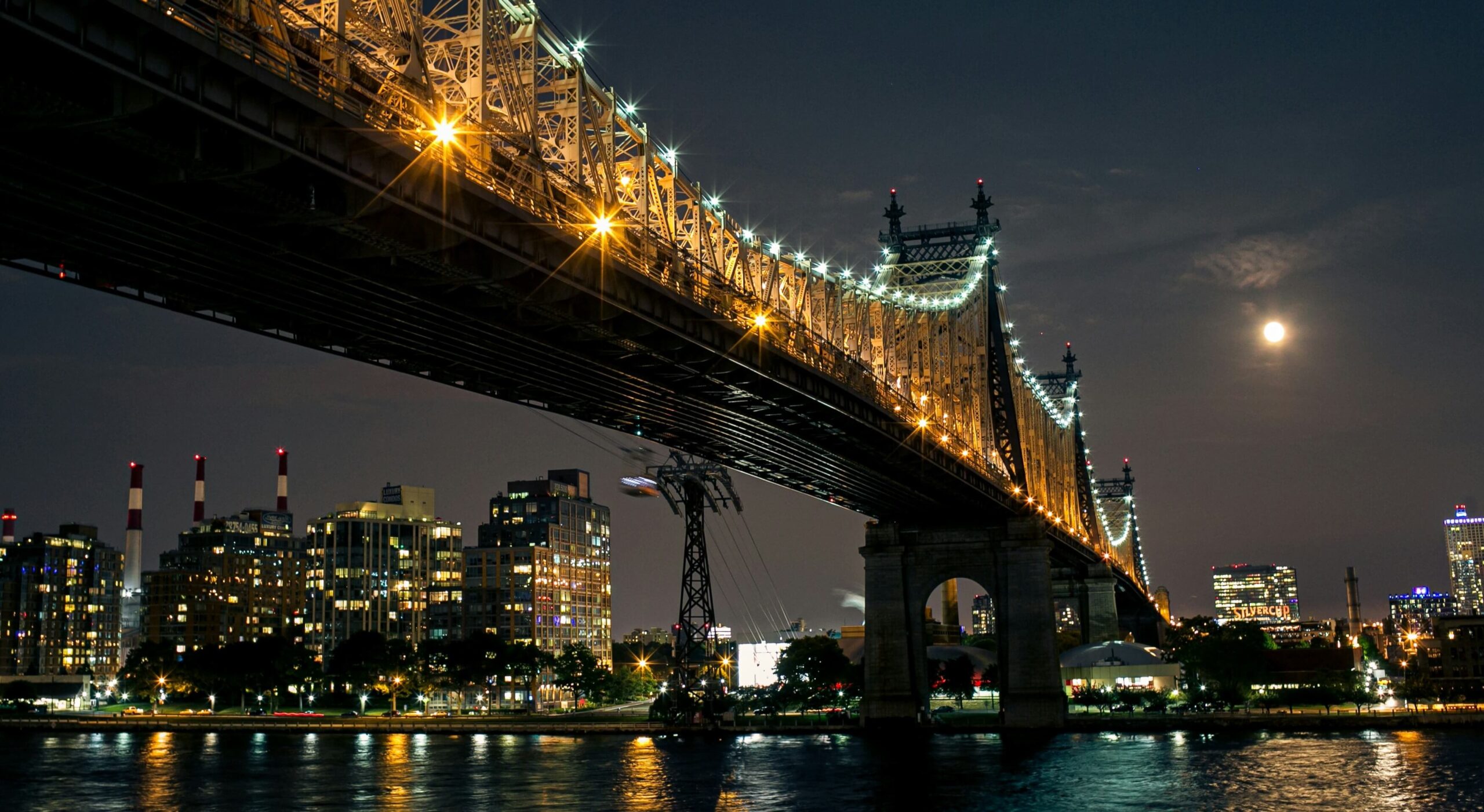 Stunning nighttime view of the Brooklyn Bridge illuminated against the New York City skyline.
