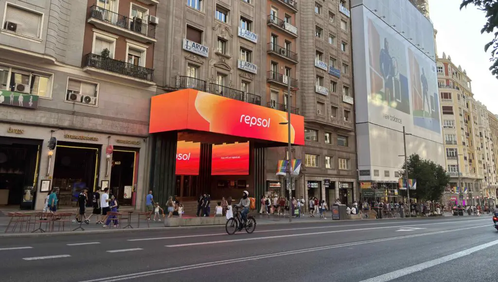 Top Free Things to Do in Madrid: Cultural Immersion on Every Corner Young woman riding a bicycle along Gran Vía in Madrid, surrounded by historic buildings and city life.
