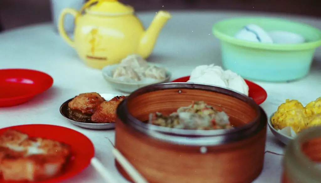A table filled with traditional Chinese dishes, including dumplings, noodles, and stir-fried vegetables, served at a restaurant in Chinatown NYC.

