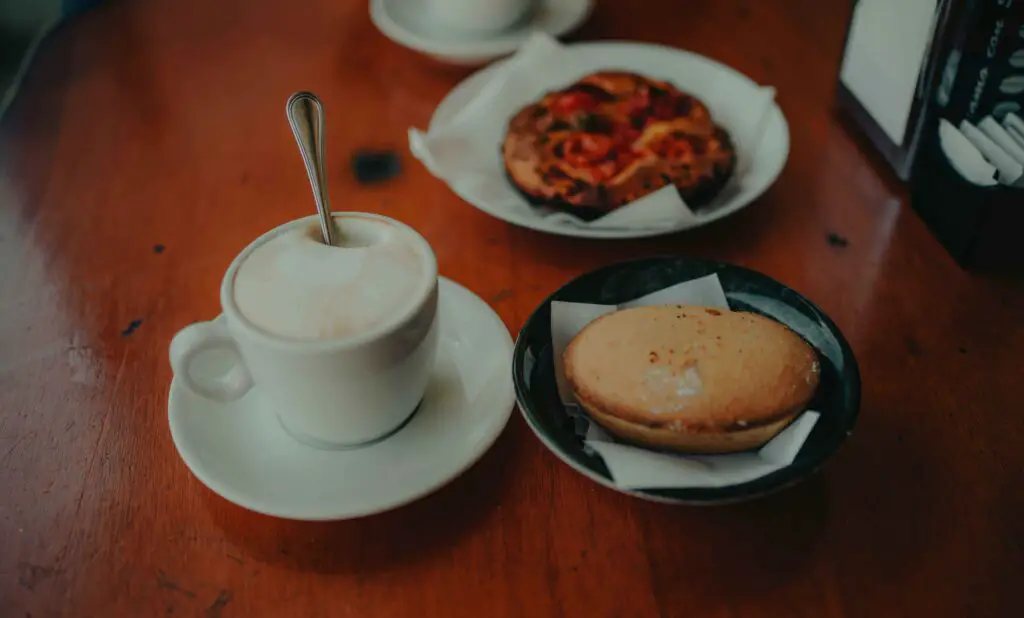 Food and Coffee Without the Fuss: Things to Do in Bushwick NYC Table with coffee cups and plates of food in a cozy café in Bushwick, NYC.