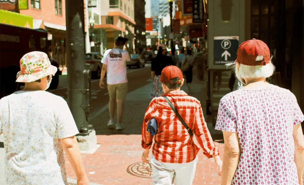 Group of people walking together on a sunny day through the elegant streets of the Upper East Side in New York City.

